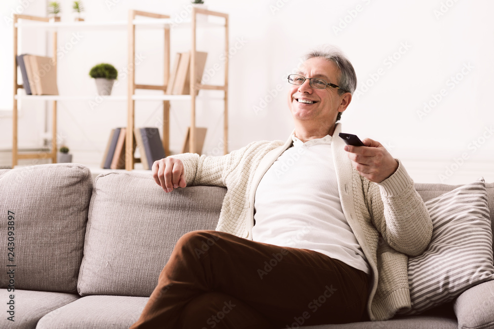 Happy senior man watching tv, sitting on couch Happy senior man watching tv, sitting on couch