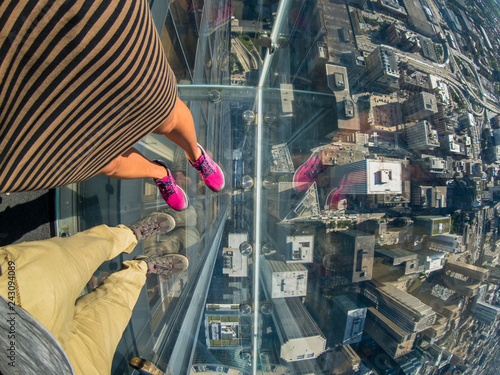 Tourists posing on a glass floor
