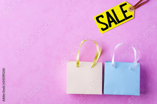 seasonal spring sale concept. special offer, sales tags, discount symbol. retail sticker and shopping bags on pastel pink background for store marketing promotion
