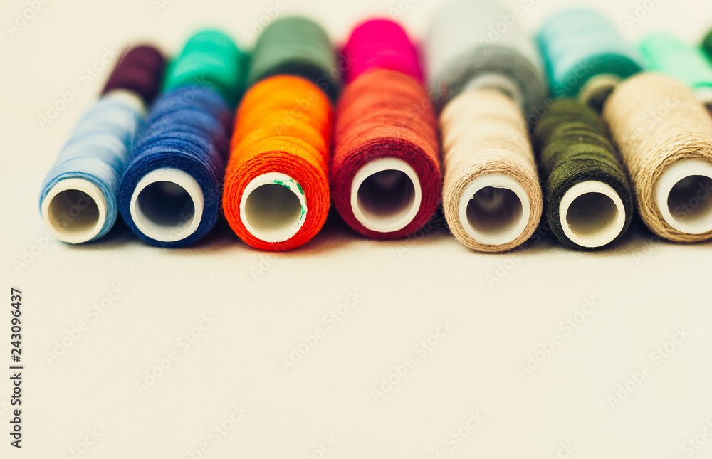 Colored sewing thread coils on white background with copy space for text. Colored sewing thread coils on white background with copy space for text.