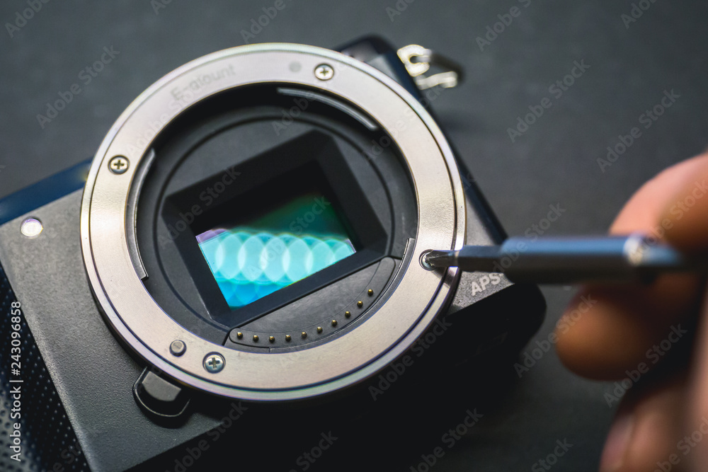 Mirrorless camera sensor repair, screwdriwer over lens mount.