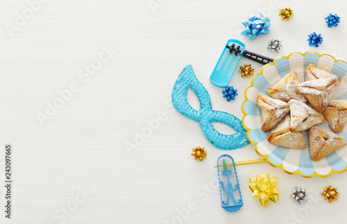 Purim celebration concept (jewish carnival holiday) over wooden white background.