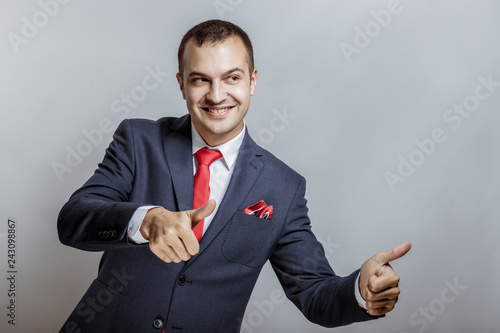 Portrait of successful arrogant overconfident professional worker wearing black classic outfit demonstrating his strength, isolated on gray background