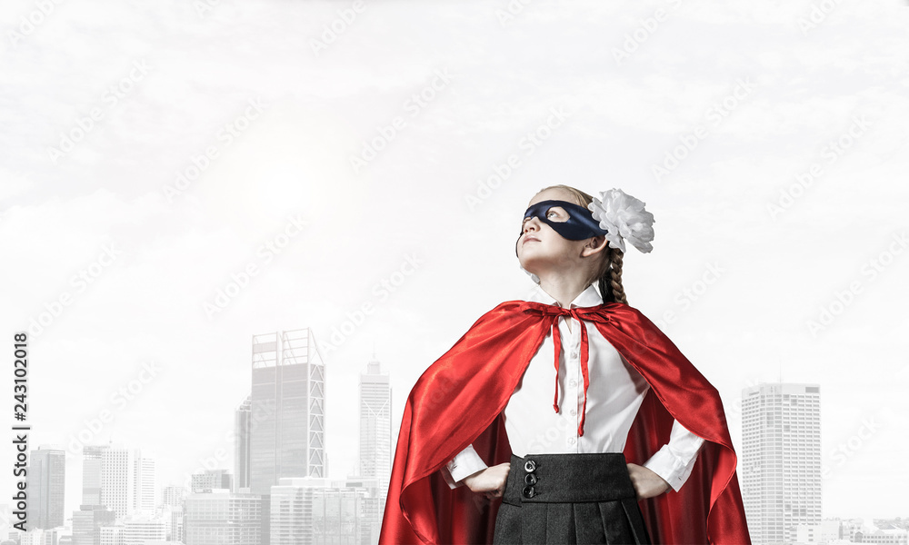 Obraz premium Girl power concept with cute kid guardian against cityscape back