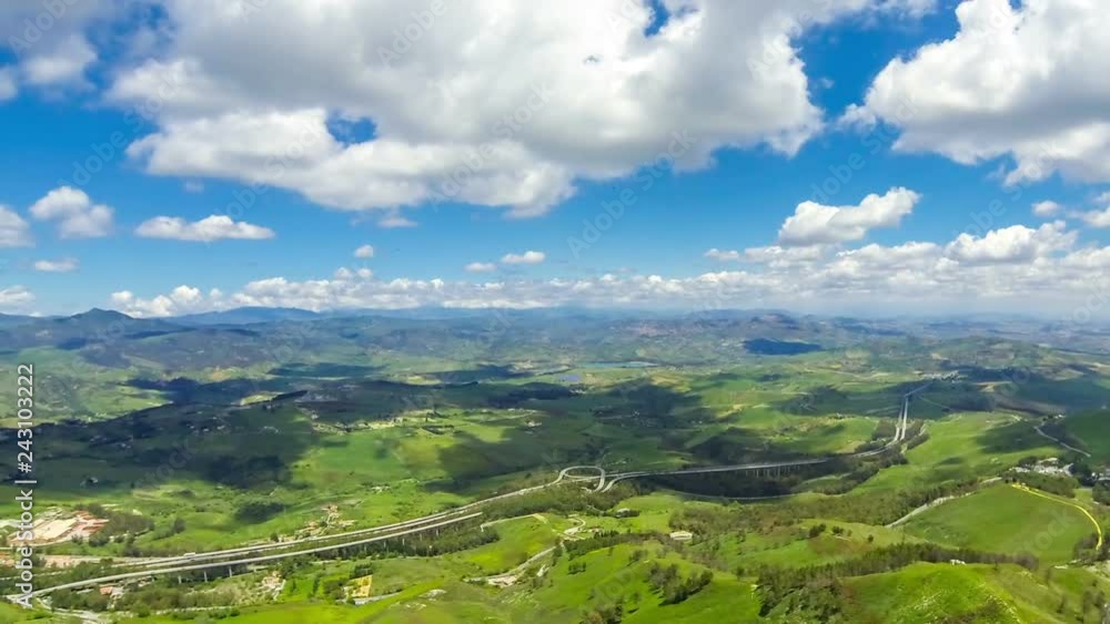Picturesque green hilly valley near Enna city, central Sicily, Italy. The Autostrada A19 from Catania to Palermo on the background. Time Lapse Picturesque green hilly valley near Enna city, central Sicily, Italy. The Autostrada A19 from Catania to Palermo on the background. Time Lapse