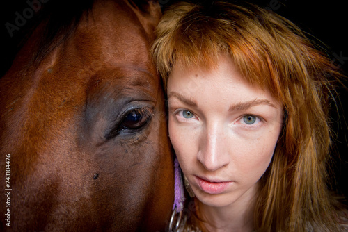 Closeup of the head of a horse and a girl in the stable.