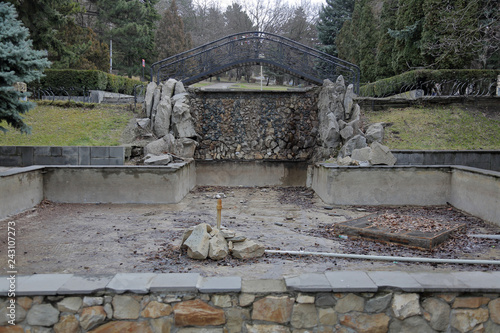 Old abandoned stone fountain in the autumn city park