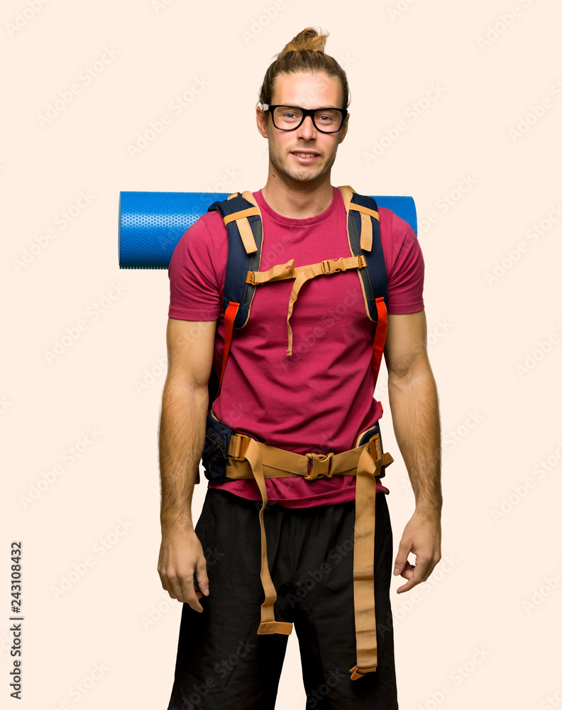 Hiker man with mountain backpacker with glasses and happy on isolated background Hiker man with mountain backpacker with glasses and happy on isolated background