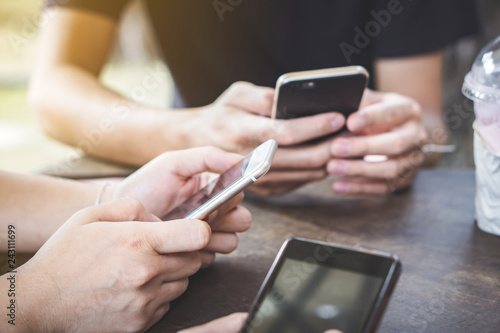 group of young friends using smart phone in a coffee shop, social addiction concept 