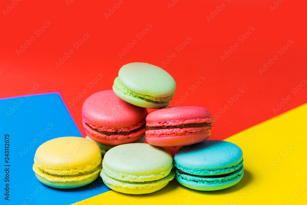 Fototapeta premium Close up of colorful red, yellow and blue background with cake macarons