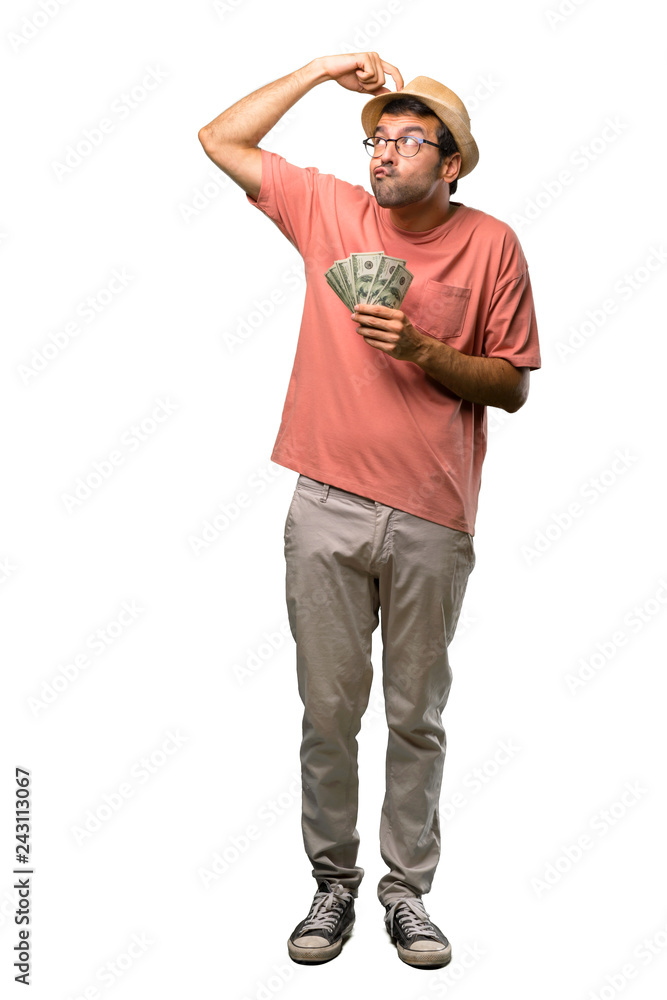 Fototapeta premium Man holding many bills having doubts while scratching head on isolated white background