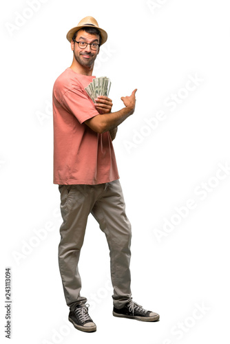Man holding many bills pointing back with the index finger on isolated white background