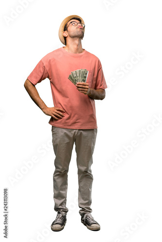 Man holding many bills looking up with serious face on isolated white background