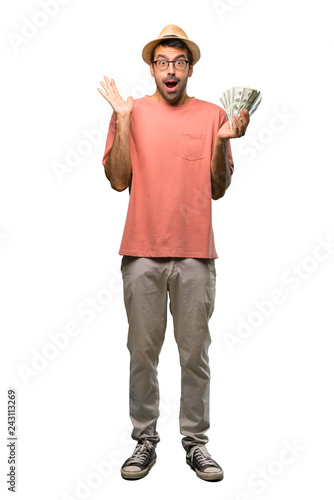 Man holding many bills with surprise and shocked facial expression on isolated white background