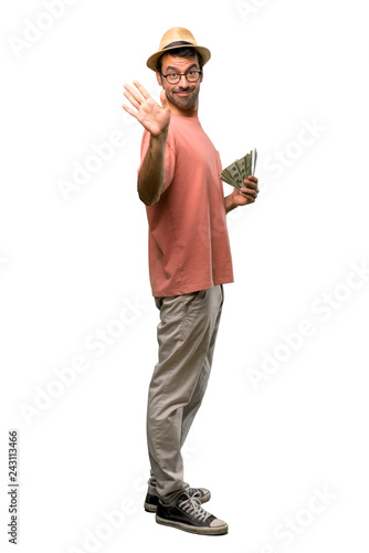 Man holding many bills saluting with hand with happy expression on isolated white background
