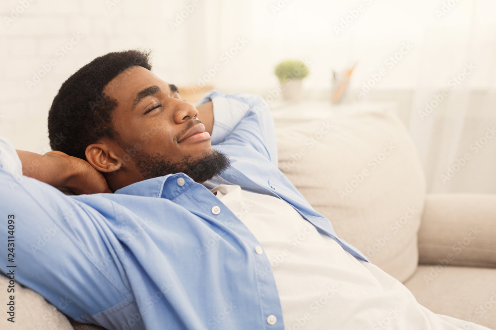 Handsome african-ameriacn man relaxing on sofa at home Handsome african-ameriacn man relaxing on sofa at home