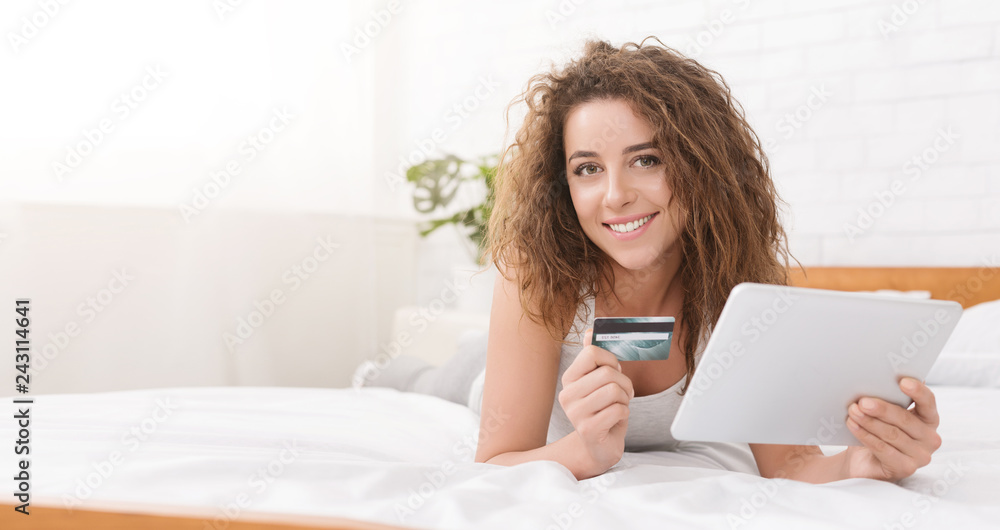 Young woman in bed doing online shopping with digital tablet Young woman in bed doing online shopping with digital tablet