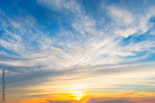 Sky blue and orange light of the sun through the clouds in the sky