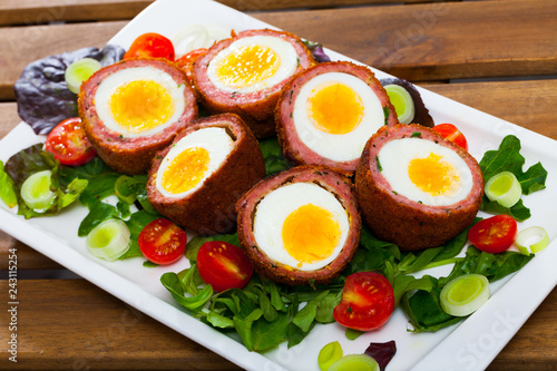 Scotch eggs with greens and tomatoes