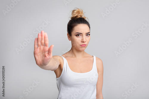 Serious woman showing stop gesture  standing with outstretched hand