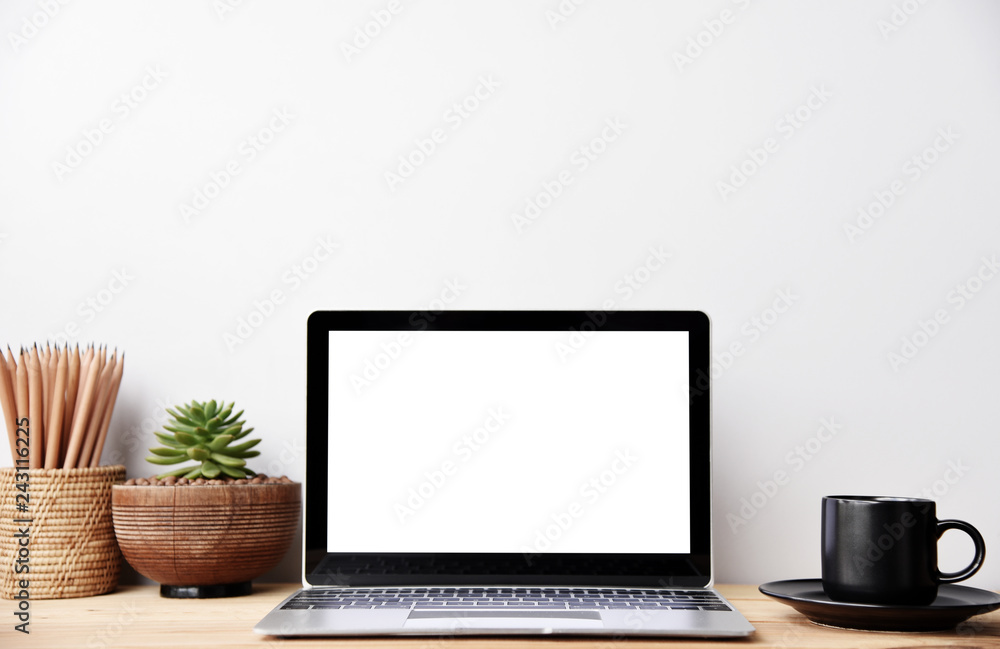 Fototapeta premium blank screen Modern laptop computer with coffee cup,mouse and Succulent on wood table in office view backgrounds