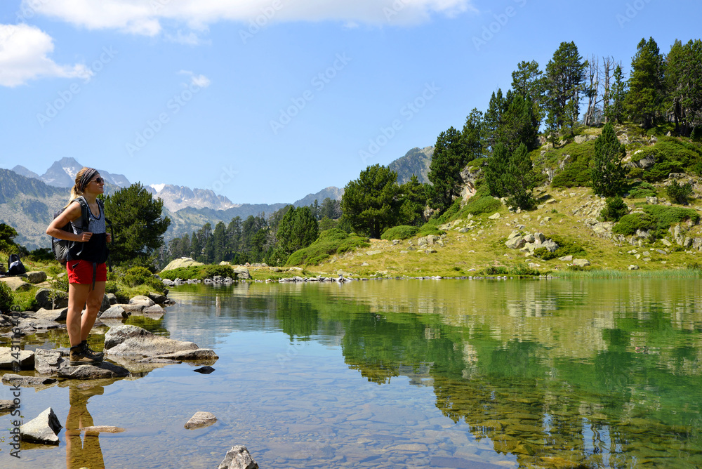 Woman tourist at the beautiful mountain lake in Neouvielle national nature reserve, Lac de Bastan inferieur, French Pyrenees. Woman tourist at the beautiful mountain lake in Neouvielle national nature reserve, Lac de Bastan inferieur, French Pyrenees.