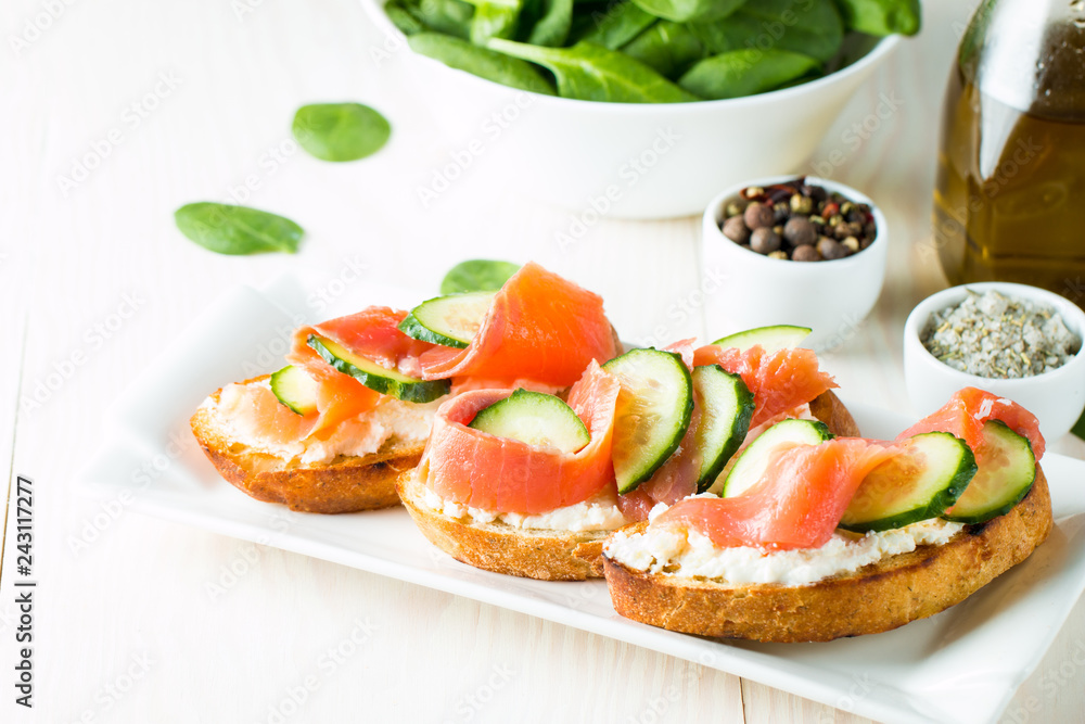 Salmon, cucumber and cream cheese bruschetta. Italian tapas, antipasti with vegetables, herbs and oil on grilled ciabatta and baguette bread. Sandwich. Salmon, cucumber and cream cheese bruschetta. Italian tapas, antipasti with vegetables, herbs and oil on grilled ciabatta and baguette bread. Sandwich.