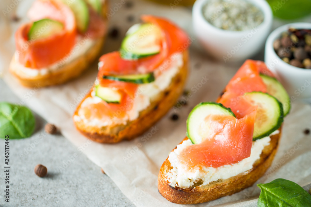 Salmon, cucumber and cream cheese bruschetta. Italian tapas, antipasti with vegetables, herbs and oil on grilled ciabatta and baguette bread. Sandwich. Salmon, cucumber and cream cheese bruschetta. Italian tapas, antipasti with vegetables, herbs and oil on grilled ciabatta and baguette bread. Sandwich.