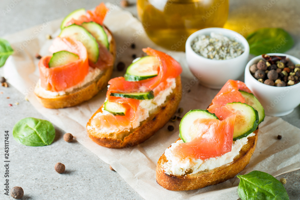 Salmon, cucumber and cream cheese bruschetta. Italian tapas, antipasti with vegetables, herbs and oil on grilled ciabatta and baguette bread. Sandwich. Salmon, cucumber and cream cheese bruschetta. Italian tapas, antipasti with vegetables, herbs and oil on grilled ciabatta and baguette bread. Sandwich.
