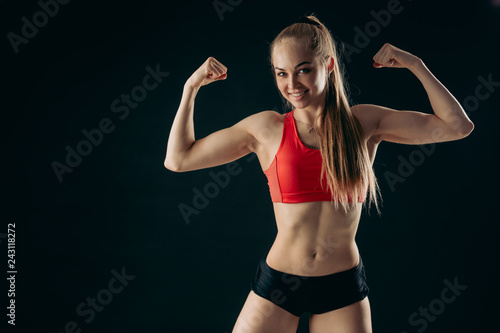 strong happy sportswoman is performing bodybuilding pose, strength, development of muscles. perfect abs , interest. ccopy space photo