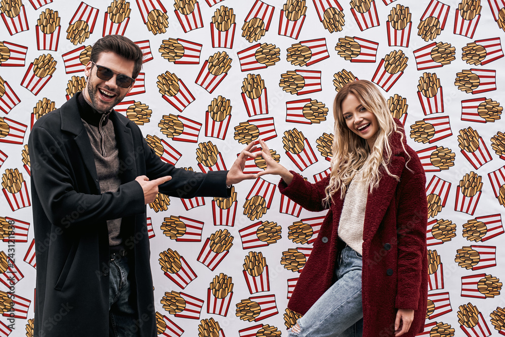 Young couple at the street brand wall background. Wall designed with street food