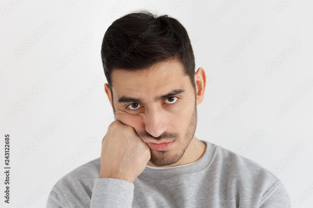 Close-up photo of young handsome man isolated on gray background, pressing hand to chin looking bored, exhausted and disappointed, feeling upset facing problems Close-up photo of young handsome man isolated on gray background, pressing hand to chin looking bored, exhausted and disappointed, feeling upset facing problems