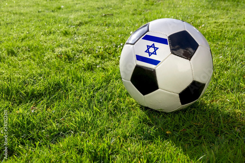 Football on a grass pitch with Israel Flag.