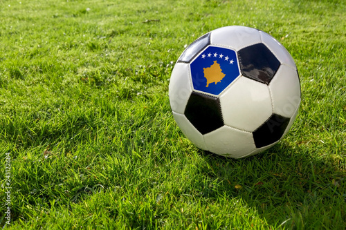 Football on a grass pitch with Kosovo Flag