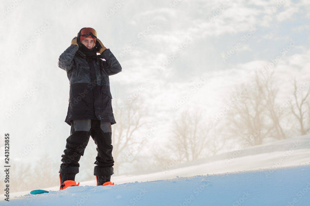 gorgeous snowboarder is standing on the top of hill. full length photo. copy space.relaxed mood. free life