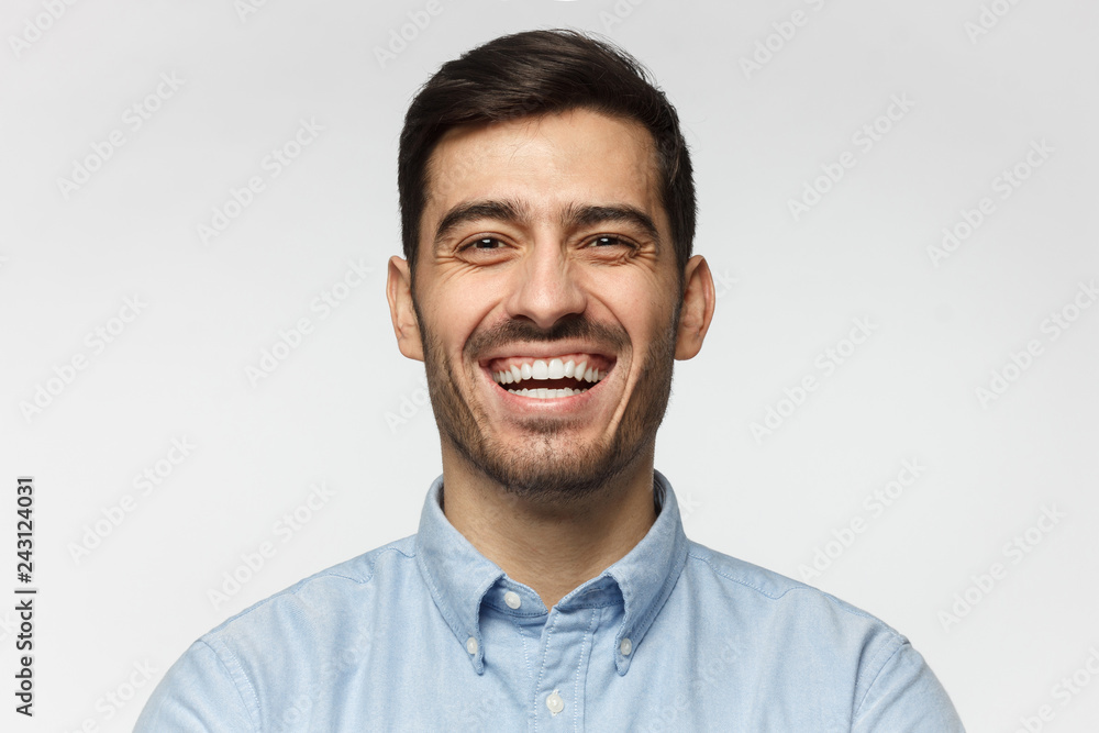 Portrait of handsome laughing business man, isolated on gray background Portrait of handsome laughing business man, isolated on gray background