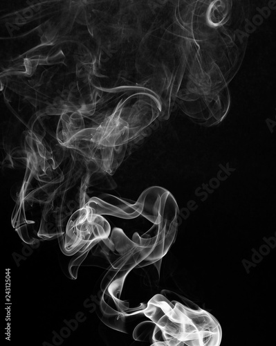 Smoke catching the light against a black background