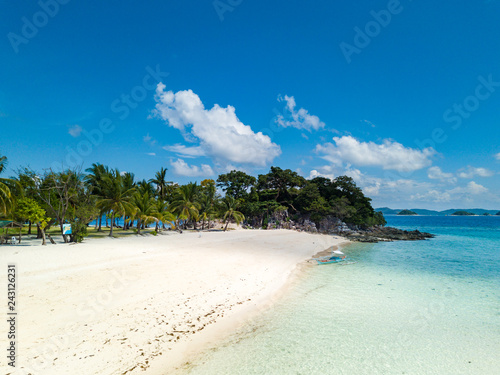 Fototapeta Naklejka Na Ścianę i Meble -  Aerial view of tropical beach on the island Malcapuya. Beautiful tropical island with sand beach, palm trees. Tropical landscape with shore and boat. Palawan, Philippines