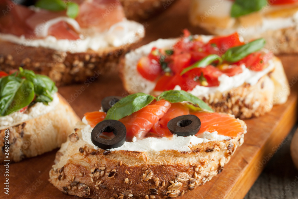 Italian tomato and cheese bruschetta. Tapas, antipasti with chopped vegetables, herbs and oil on grilled ciabatta and baguette bread.