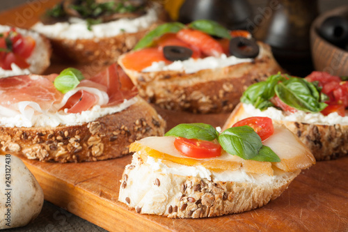 Italian tomato and cheese bruschetta. Tapas, antipasti with chopped vegetables, herbs and oil on grilled ciabatta and baguette bread.