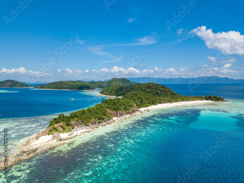 Aerial view of tropical beach on the island Malcapuya. Beautiful tropical island with sand beach, palm trees. Tropical landscape with shore and boat. Palawan, Philippines photo