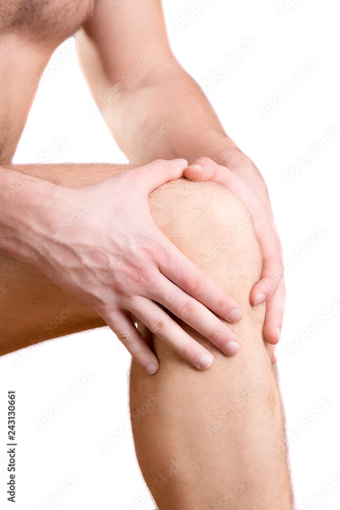 A man touches a sore knee on a white background. A man touches a sore knee on a white background.