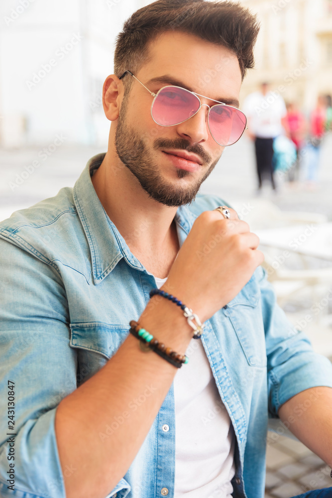 portrait of attractive casual man wearing red sunglasses sitting Stock  Photo | Adobe Stock