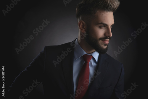 portrait of attractive businessman looking to side while standing