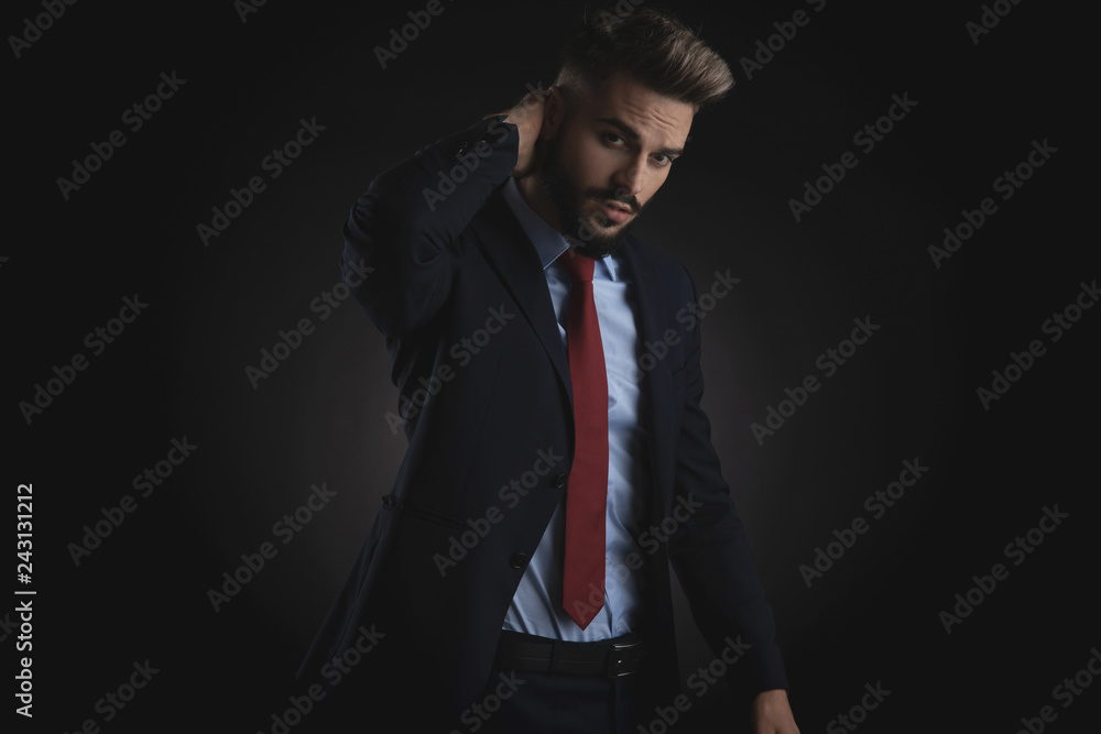 portrait of young businessman holding back of head