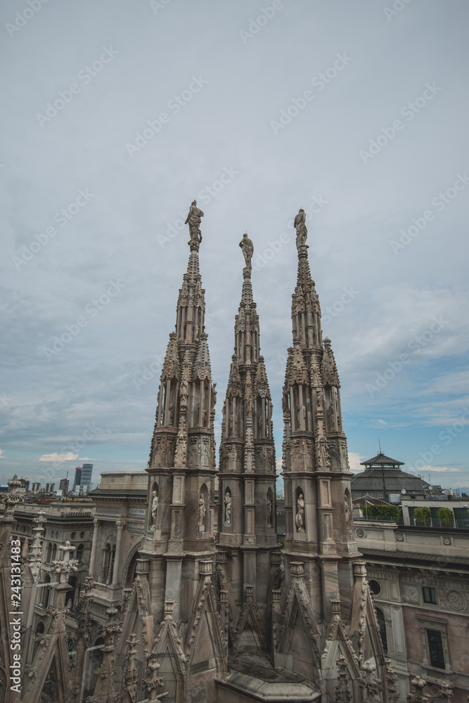 Fototapeta premium Roof terraces of gothic Milan Cathedral, or Duomo di Milano, at sunset. The beautiful gothic cathedral is the main tourist attraction of Milan, Lombardy, Italy