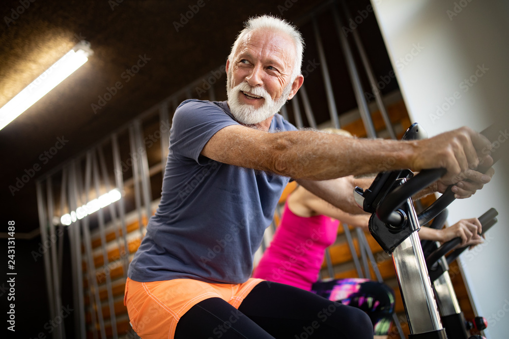 Happy senior people doing exercises in gym to stay fit Happy senior people doing exercises in gym to stay fit