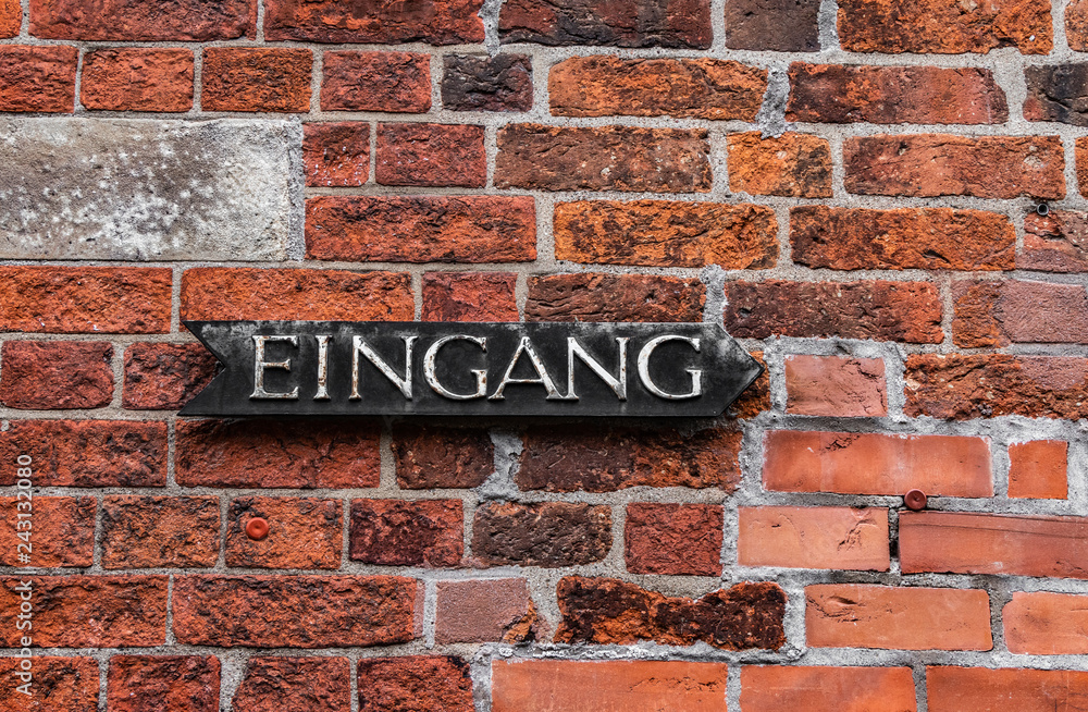 Eingangsschild an Backsteinwand Eingangsschild an Backsteinwand