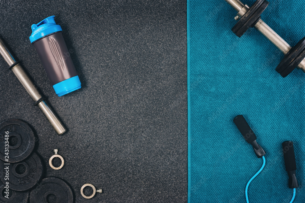 Fitness or bodybuilding concept background. Product photograph of old iron dumbbells on black grey, conrete floor in the gym. Photograph taken from above, top view with lots of copy space Fitness or bodybuilding concept background. Product photograph of old iron dumbbells on black grey, conrete floor in the gym. Photograph taken from above, top view with lots of copy space