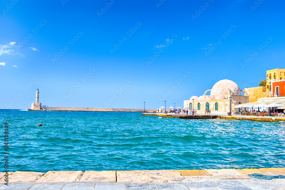Travel ideas. Chania Old Port and Venetian Harbor With Ancient Lighthouse on Background. Travel ideas. Chania Old Port and Venetian Harbor With Ancient Lighthouse on Background.
